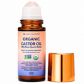 Organic castor oil bottle with rose quartz roller on a white background