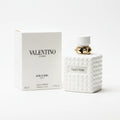 Valentino perfume bottle and packaging on a marble surface with a dark background